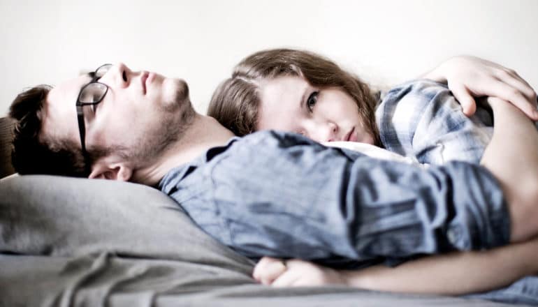 sad couple lies down together