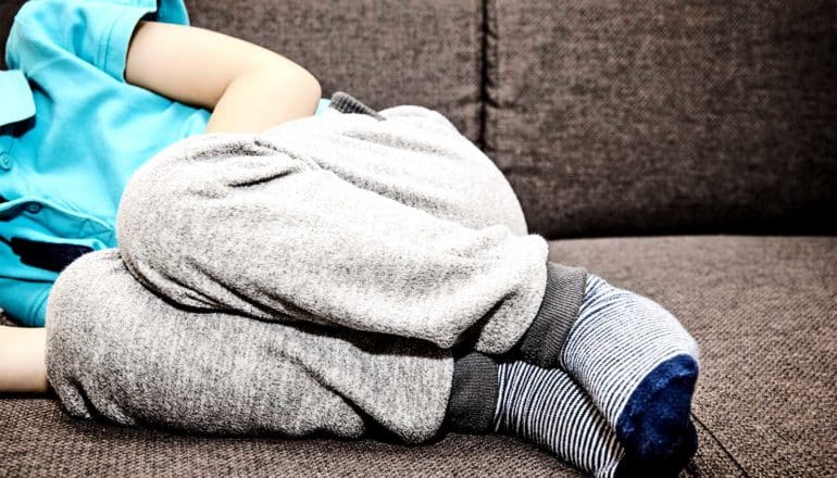 Boy feeling ill on the couch (Autism concept)