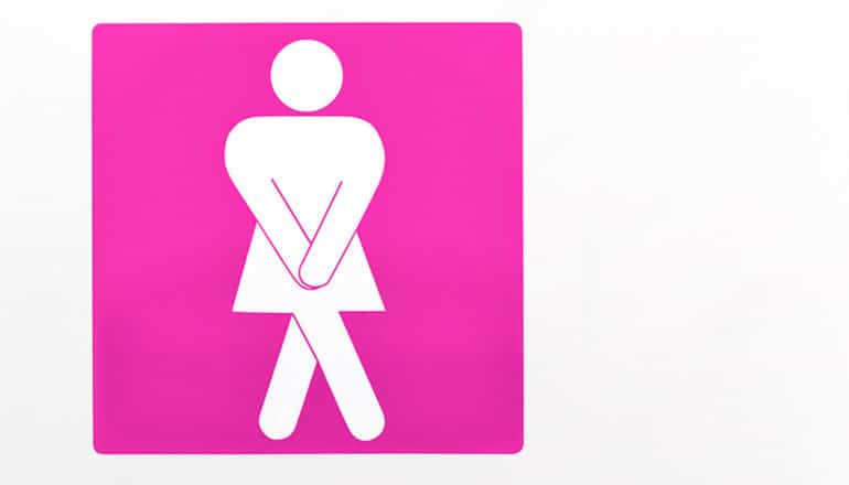 A bathroom sign shows a woman crossing her legs and clasping hands together.