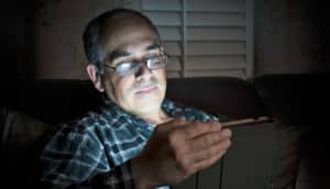 man uses tablet in dark