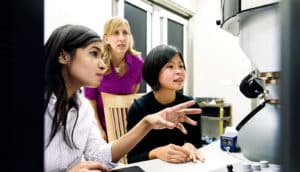 researchers at microscope