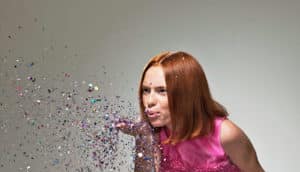 woman blows confetti