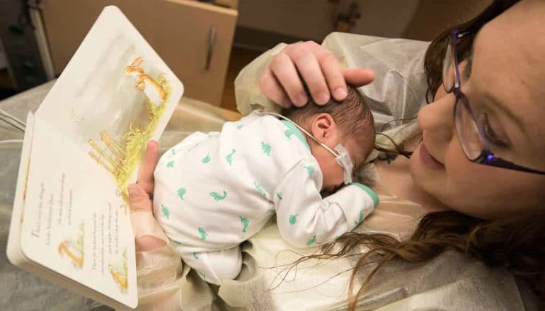mom holds baby in NICU