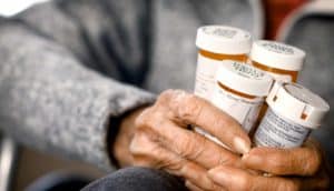 hands holding pill bottles