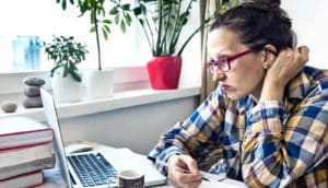 woman looks angrily at computer