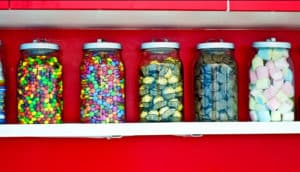 jars of candy against red wall