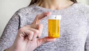 woman's hand holds pill bottle