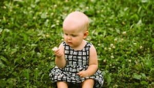 toddler holds a flower