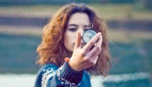 woman holds up compass