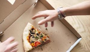 man grabs last slice of pizza