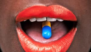 red lipstick and pill on tongue