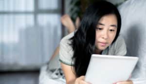 woman reading news on the couch