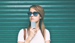 woman with phone wears sunglasses
