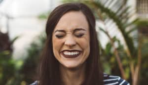 woman blushing with eyes closed