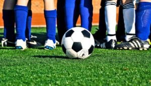 soccer ball on field with kids