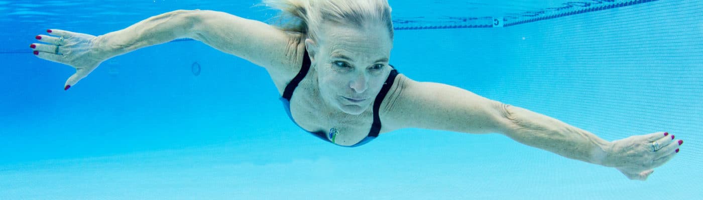 older woman swims under water
