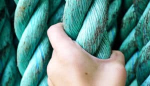 hand grasps teal rope