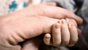 baby holding finger close-up