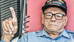 elderly veteran holds up hand