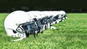 football helmets in line on grass