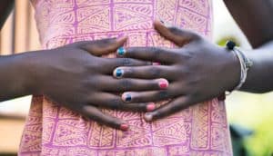 girl with nail polish holds hands on stomach
