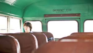 lone teen boy on school bus