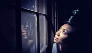 woman looks up and out window