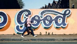man walking past graffiti