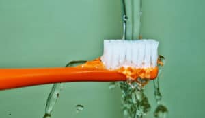 orange toothbrush on green