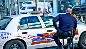 police officer sitting on stool outside car