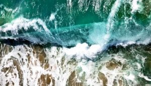 wave crashing on shore in overhead shot