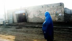 woman in blue walks in Afghanistan