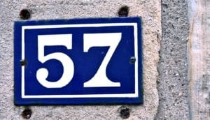57 on blue plaque on concrete wall