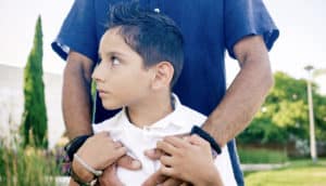 boy holding onto dad's arms