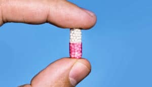 capsule between fingers