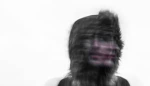 blurry face of woman wearing fur hood