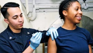 man gives smiling woman flu shot