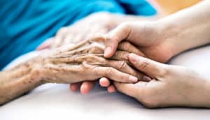 caregiver holding elderly hand