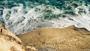 aerial shot of the ocean and man walking