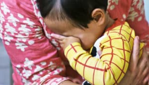 toddler hides face against mom