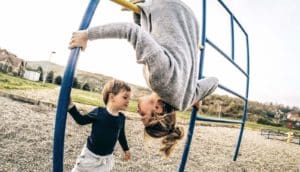 mom upside down on playground with toddler