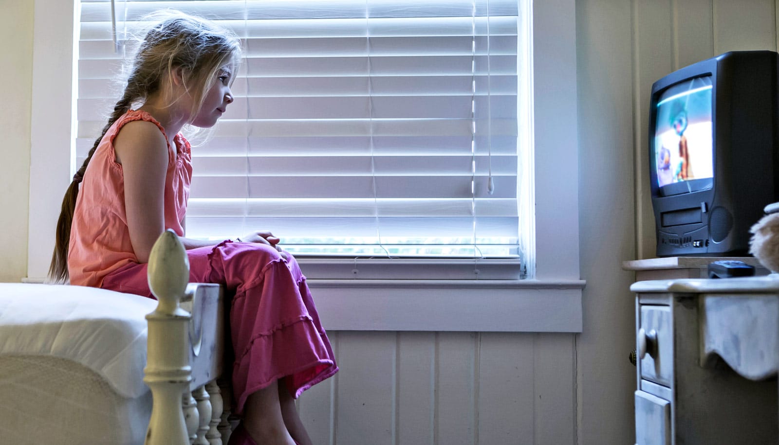 Research news from top universities. girl watches TV in bedroom. 