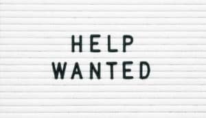 black "help wanted" on white sign
