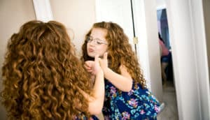 little girl looking in the mirror