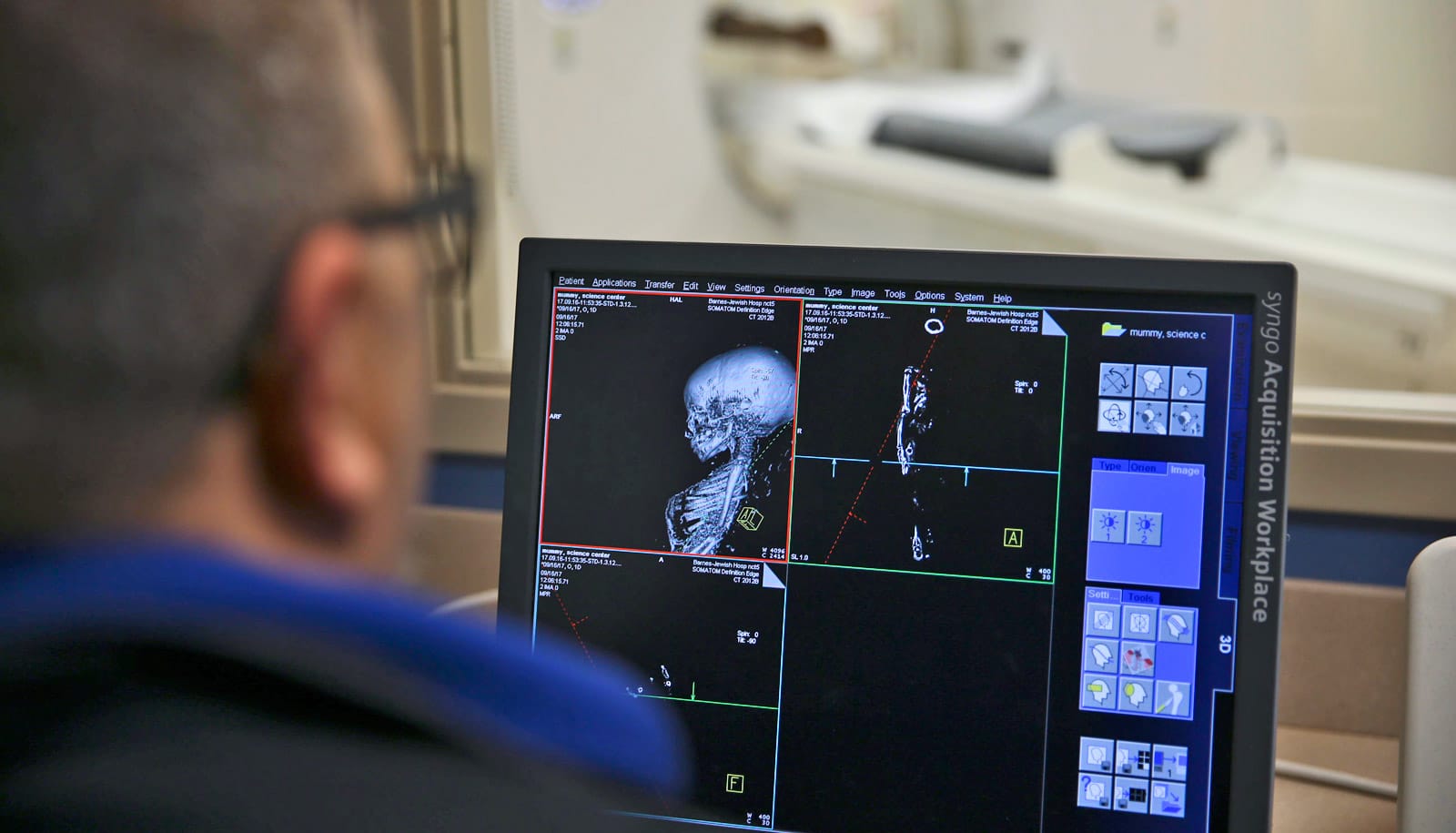 scientist looks at ct scan of baby mummy