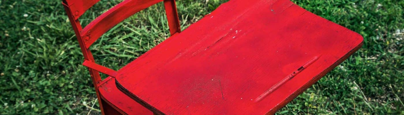 red school desk on grass