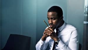 worried man holds pencil in office