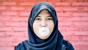young muslim woman with bubblegum