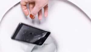 hand drops iphone into toilet