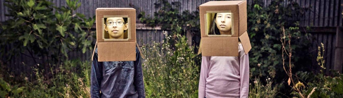two kids wear cardboard robot costume hats